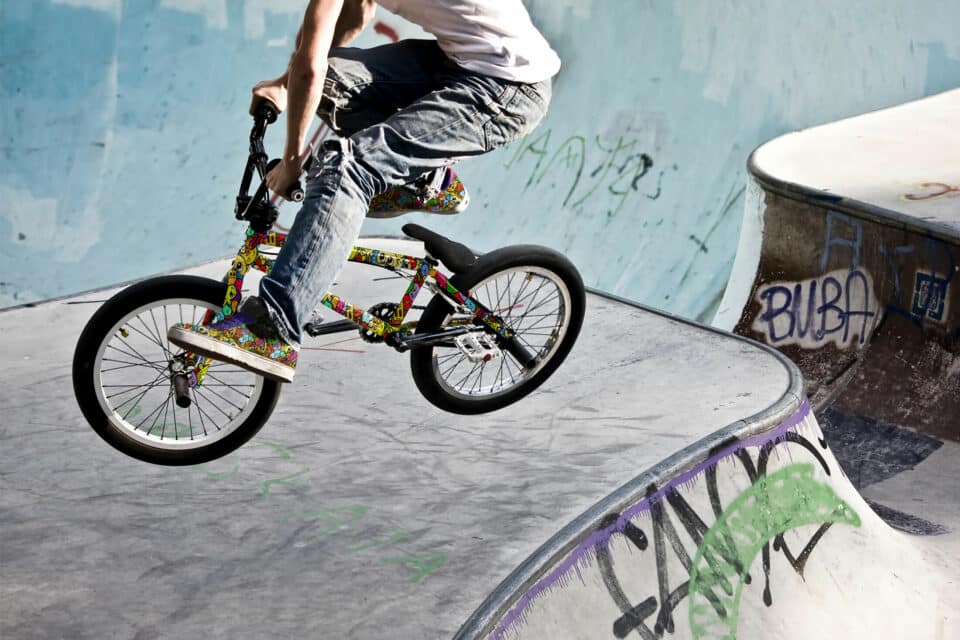 Radfahrer auf buntem BMX Rad mit passenden bunten Schuhen in Saktepark